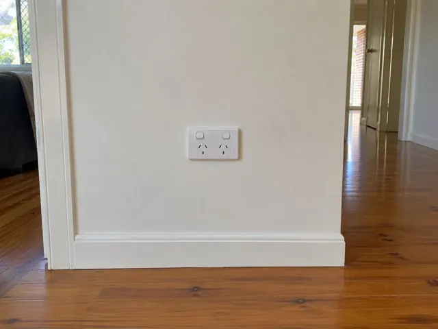White double power point on a cream hallway wall with timber floorboards in Pacific Pines